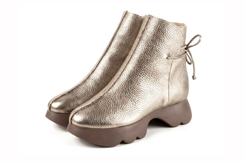 Feminine back lace-up ankle boots featuring romantic corset-style ties, designed for a striking silhouette from day to evening, in gold leather with round toe and chunky rubber sculpted sole
